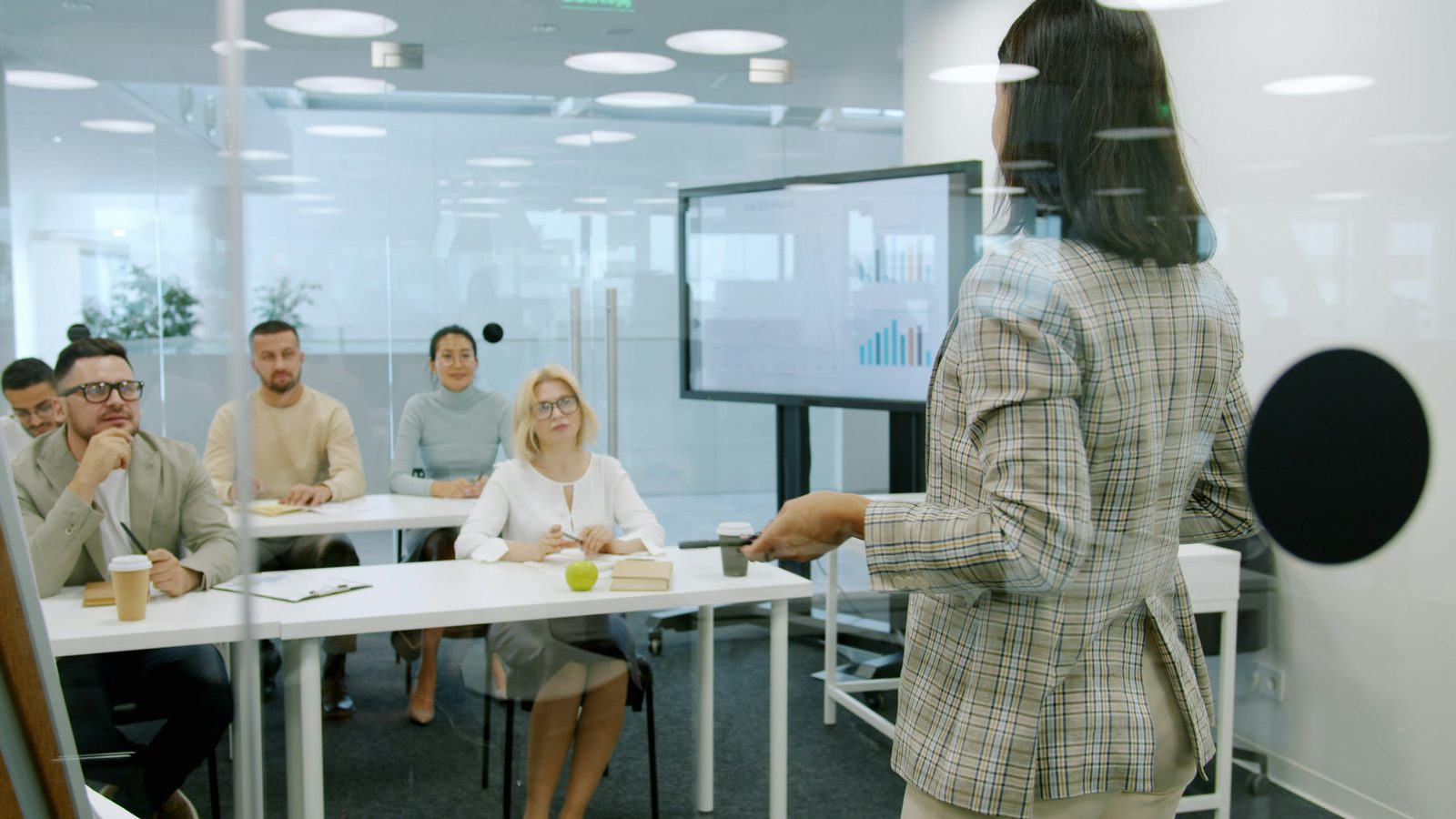 Facilitator presenting to an attentive audience in a modern training room