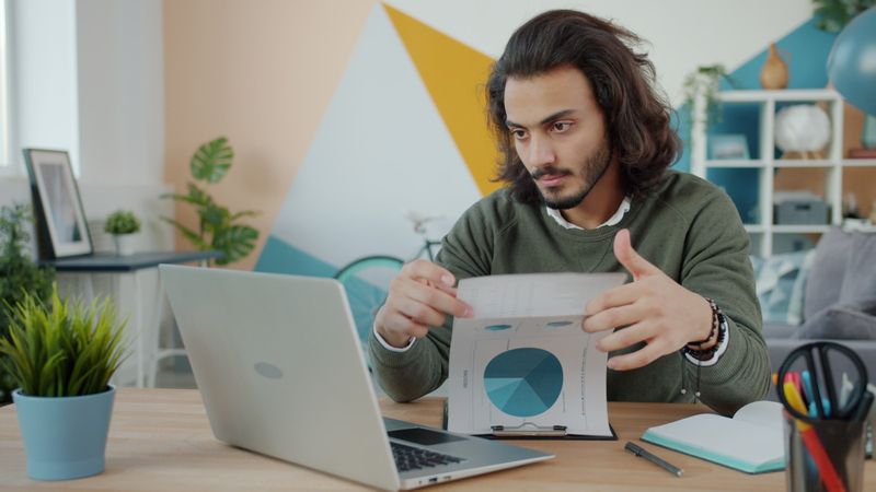 Business owner reviewing documents at a laptop